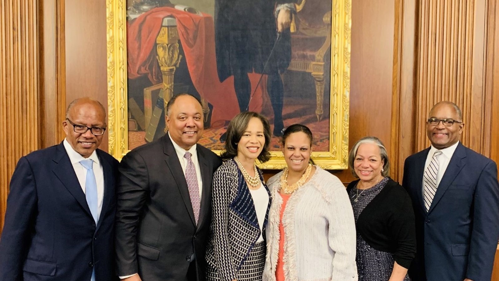 Libi Sprow Rice with a delegation beneath a portrait of George Washington